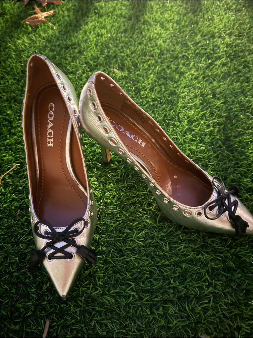 COACH Metallic Silver Pointed Toe Pumps with Black Lace Bow